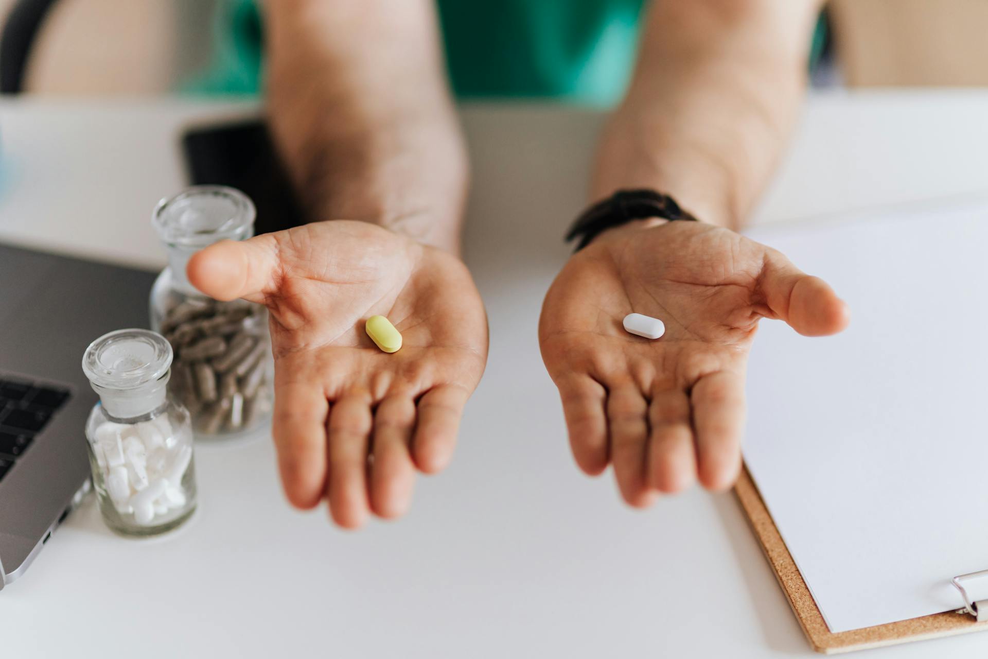 Person holding painkiller tablets at home while dealing with chronic pain