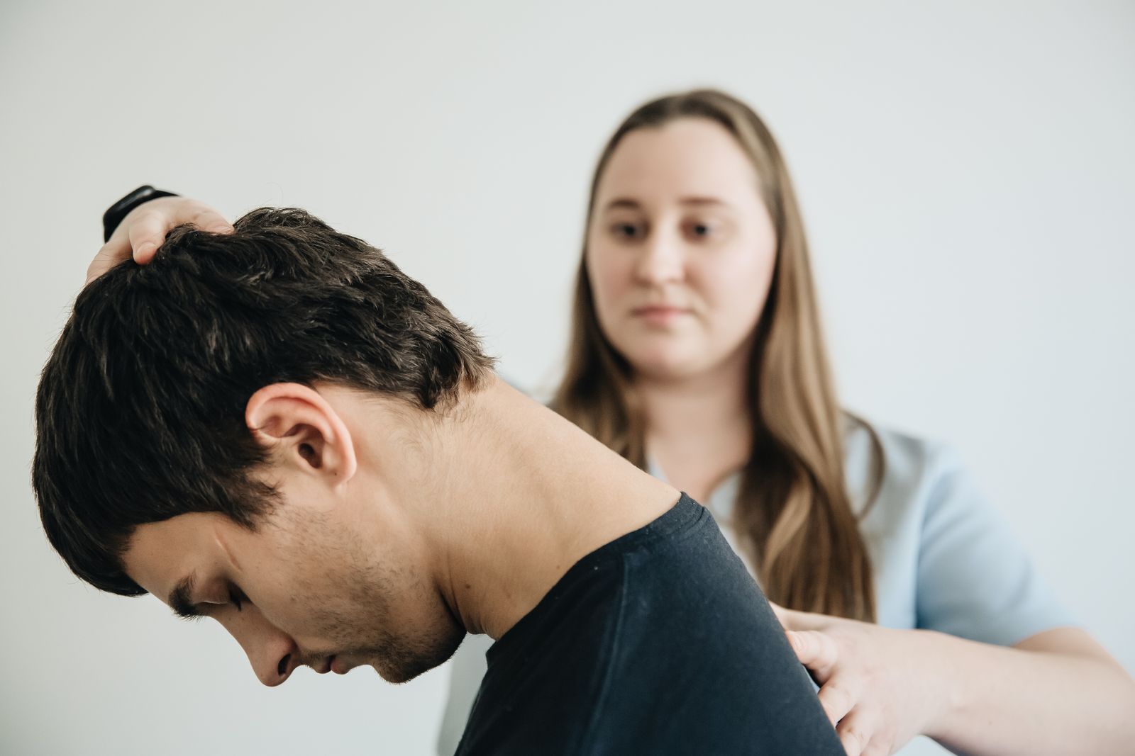Physiotherapist supporting a seated person's head and upper back