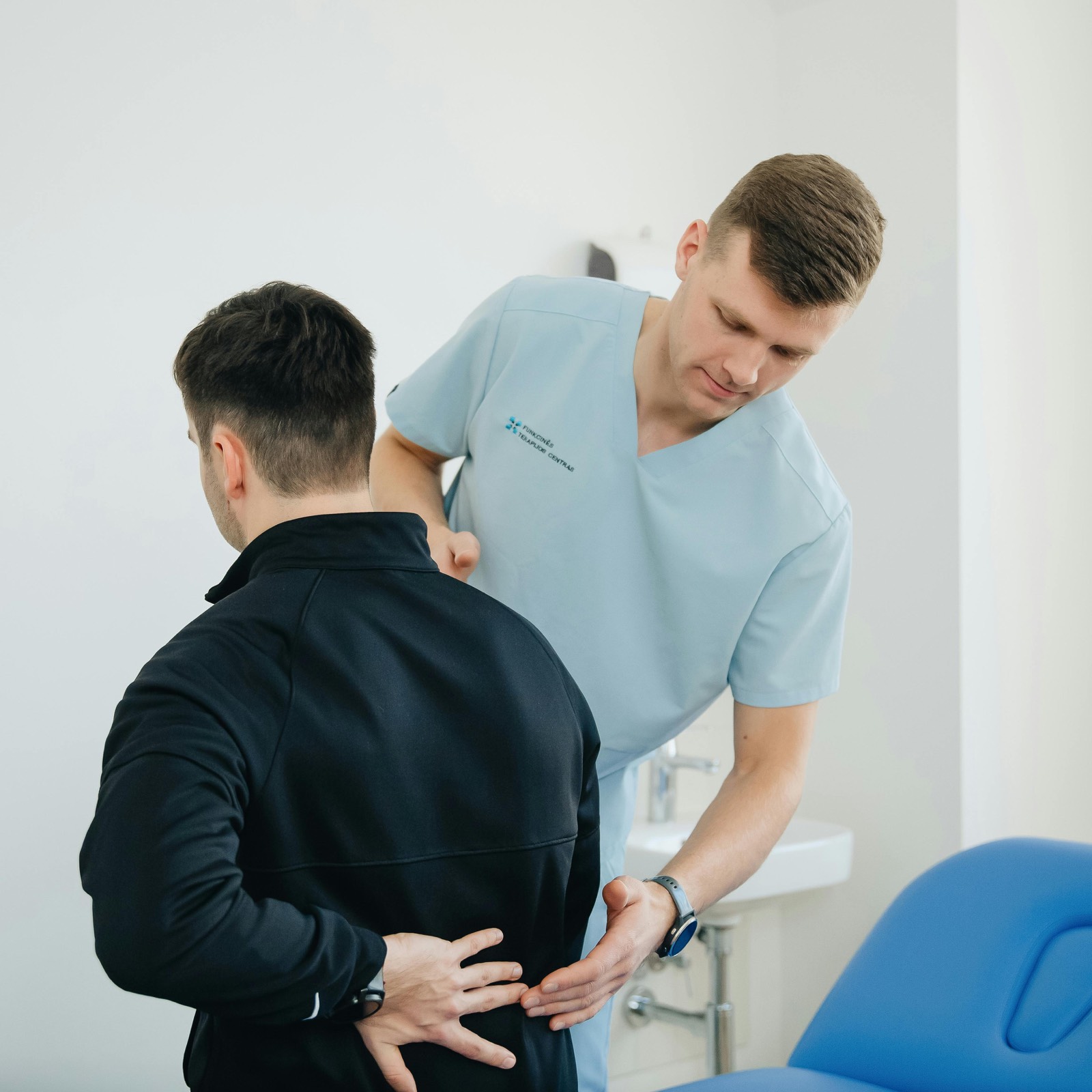 Doctor examining lower back and pelvis area for sacroiliac joint pain