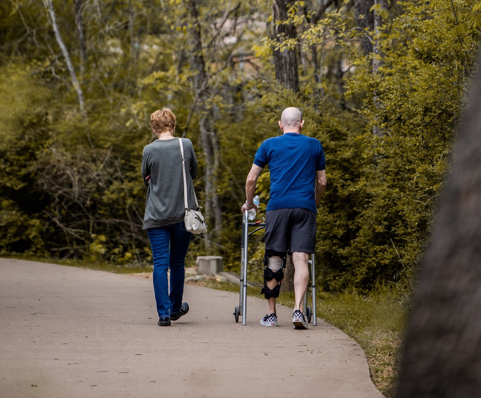 Person walking with a mobility aid due to pain and gait difficulty